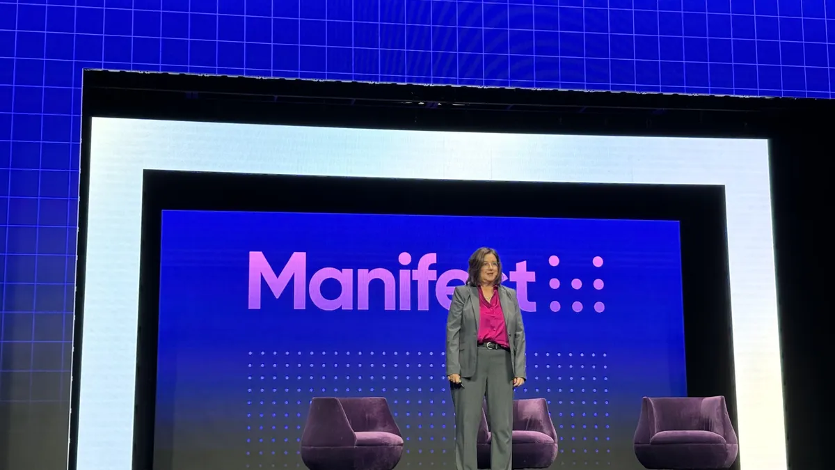 DHL Supply Chain exec stands on a stage during a keynote presentation at Manifest 2024 in Las Vegas.