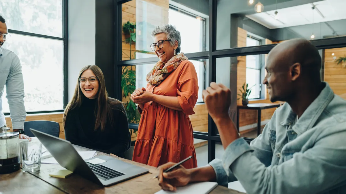 Diverse businesspeople smiling cheerfully during a meeting in a modern office. Group of successful businesspeople working as a team in a multicultural workplace.