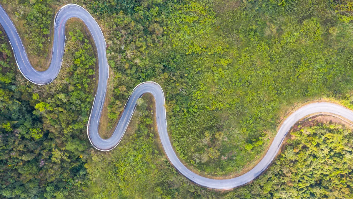 Aerial top view of a winding road in the forest