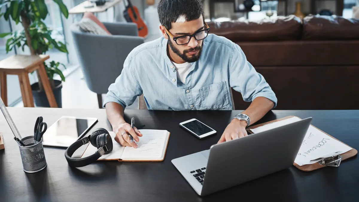 Shot of a young man using his laptop while working from home