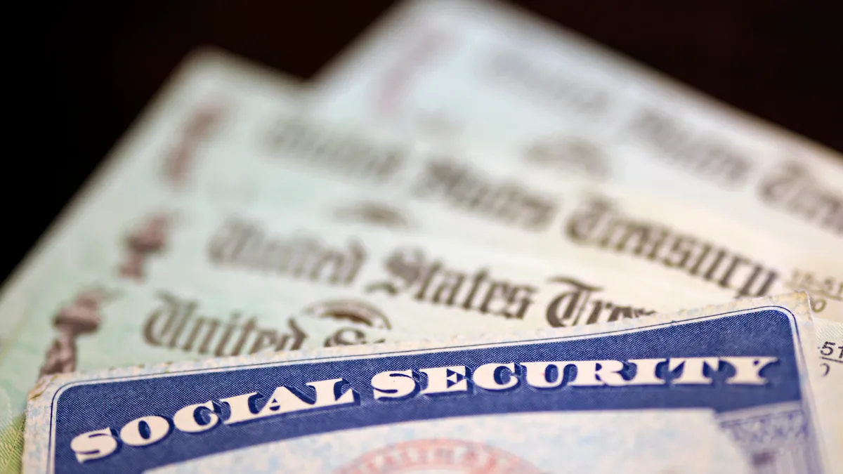 A Social Security card sits next to US Treasury checks.