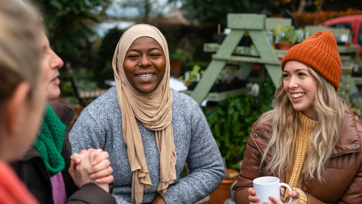 A multicultural group of women enjoy hot drinks in the winter time