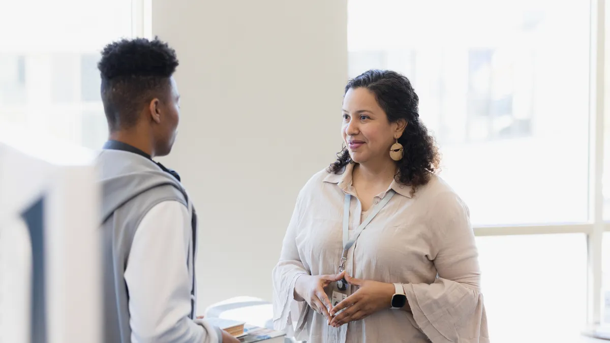 A millennial patiently listens to a Gen Z coworkers