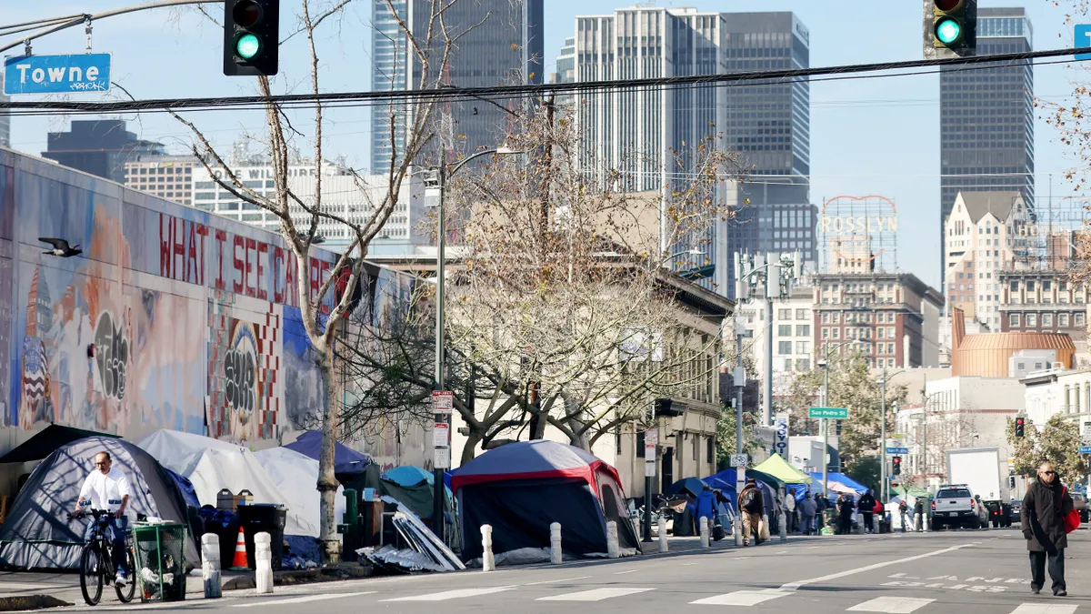 Tents line a street in front of high-rise buildings