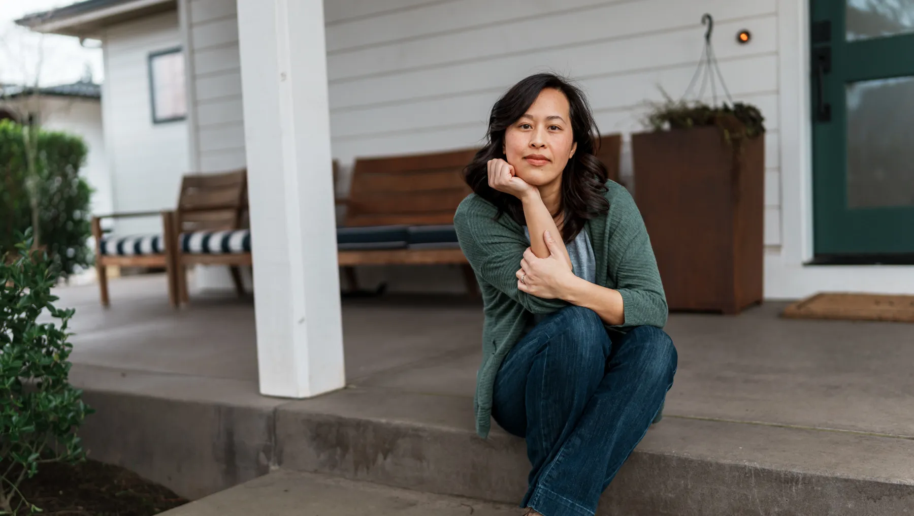 A Vietnamese person sits on front step of their home