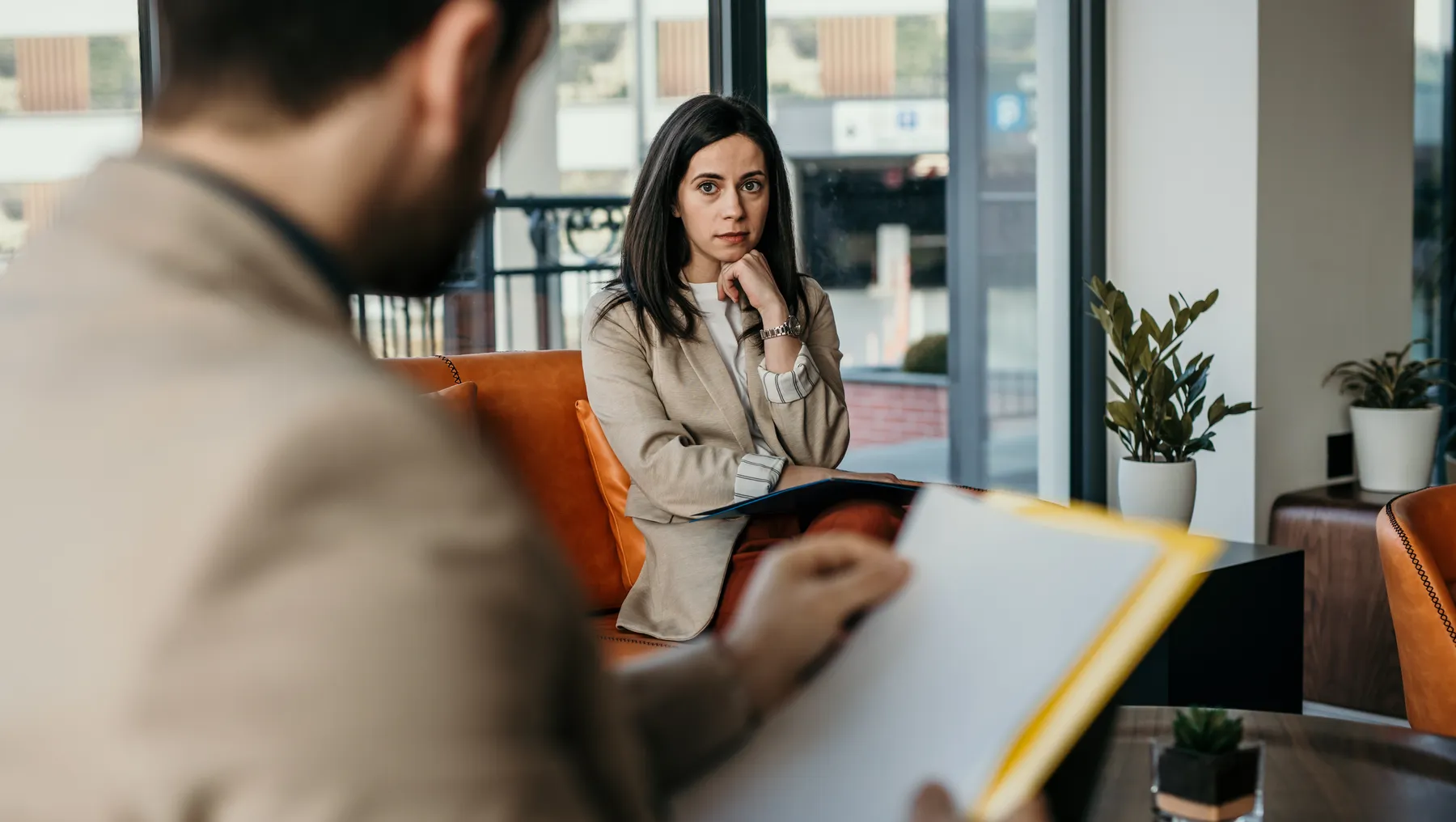 Worried person with guarded body language thinks of something while having a job interview at the corporate office