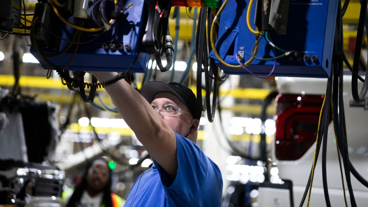 An employee works on a truck assembly line.