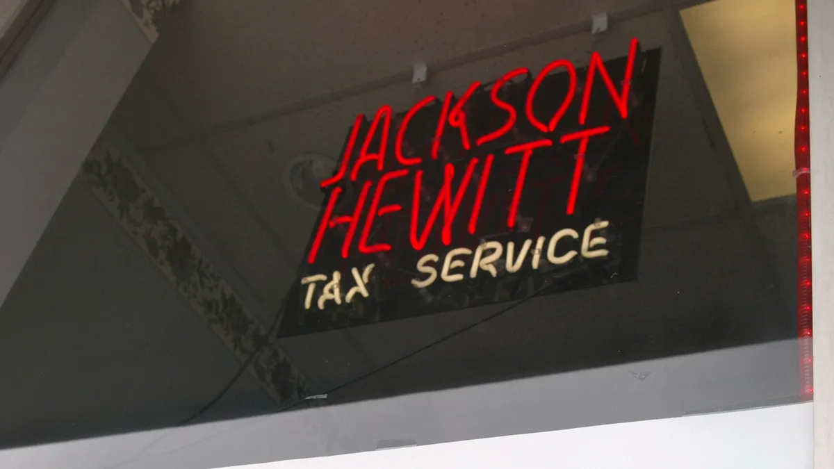 A neon Jackson Hewitt sign in red.