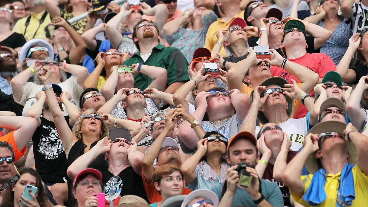 People watch the solar eclipse at Saluki Stadium on the campus of Southern Illinois University on Aug. 21, 2017 in Carbondale, Illinois.