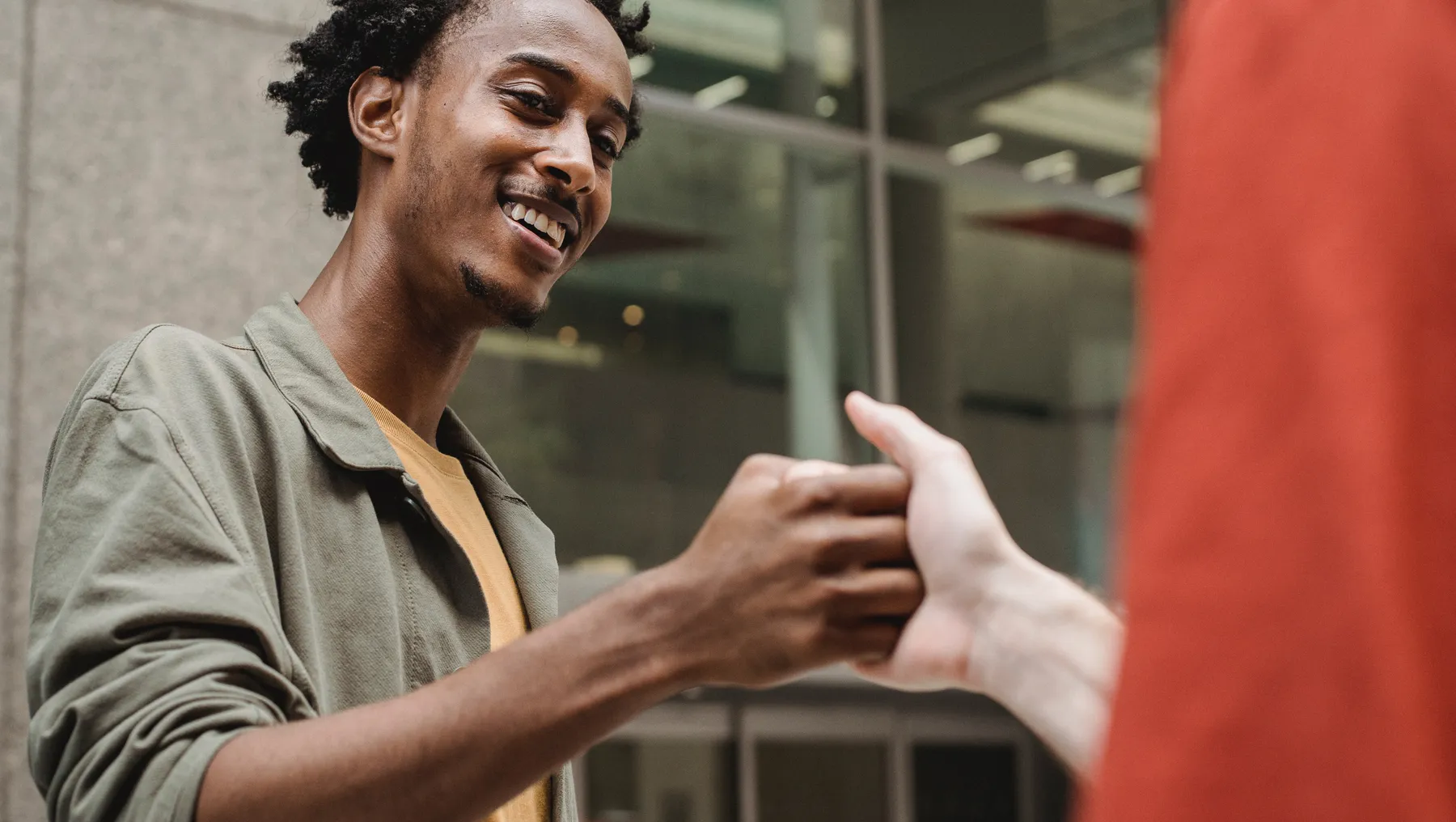 A Black person locks hands with a White co-worker